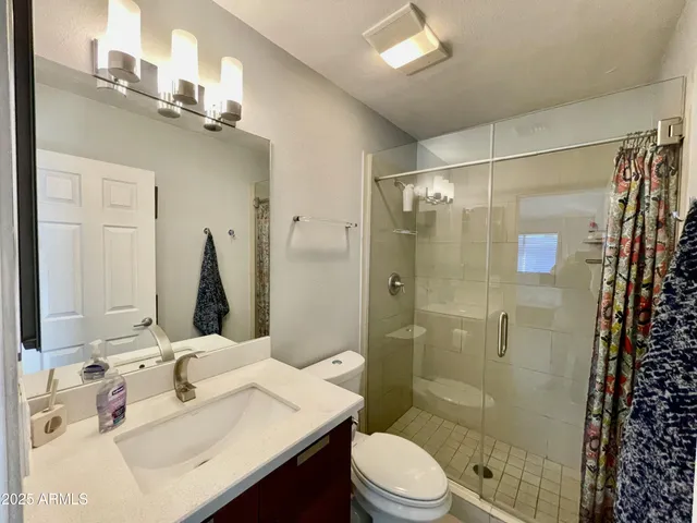 a bathroom with a sink a toilet and shower