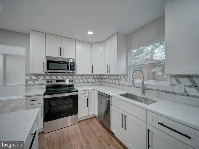 a kitchen with stainless steel appliances a sink stove and refrigerator