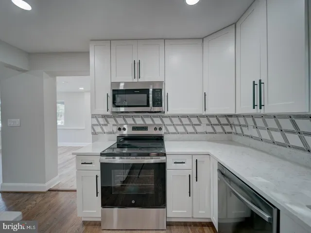 a kitchen with a sink chandelier and wooden floor