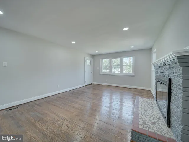 an empty room with windows and fireplace