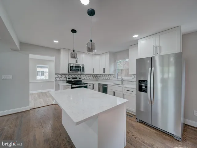 a kitchen with white cabinets stainless steel appliances and sink