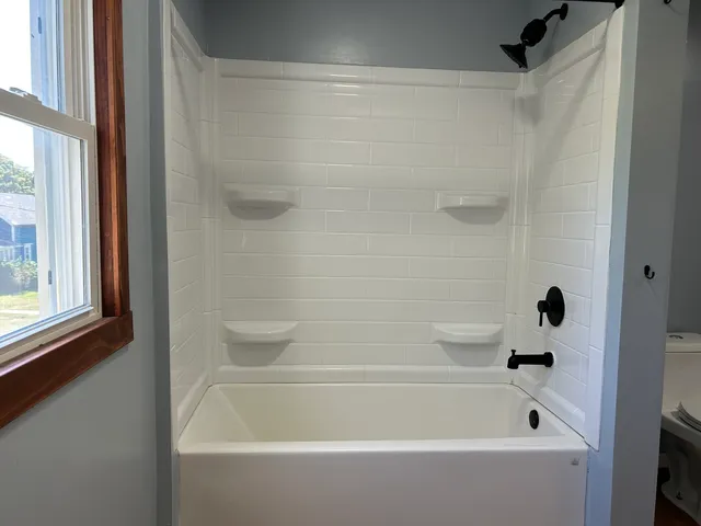 a bathroom with a shower and a bath tub