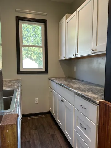 a kitchen with granite countertop white cabinets and white appliances