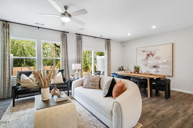 a living room with furniture a dining table and chairs with wooden floor