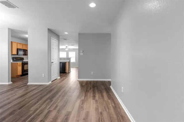 a view of a room with wooden floor and a kitchen