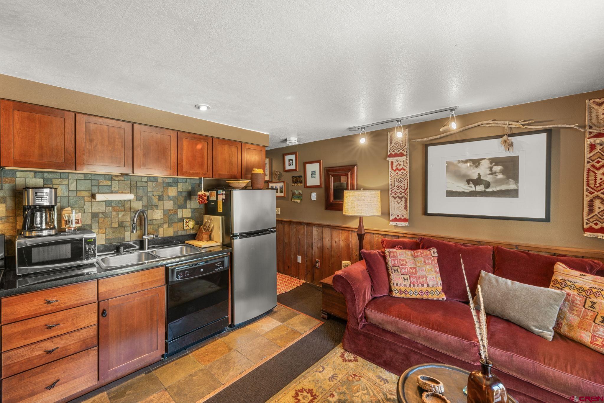 701 Gothic Road, Unit 143 Crested Butte, CO 81225 - Photo 4 of 30 a kitchen with stainless steel appliances granite countertop a refrigerator a stove a sink and a cabinets with wooden floor