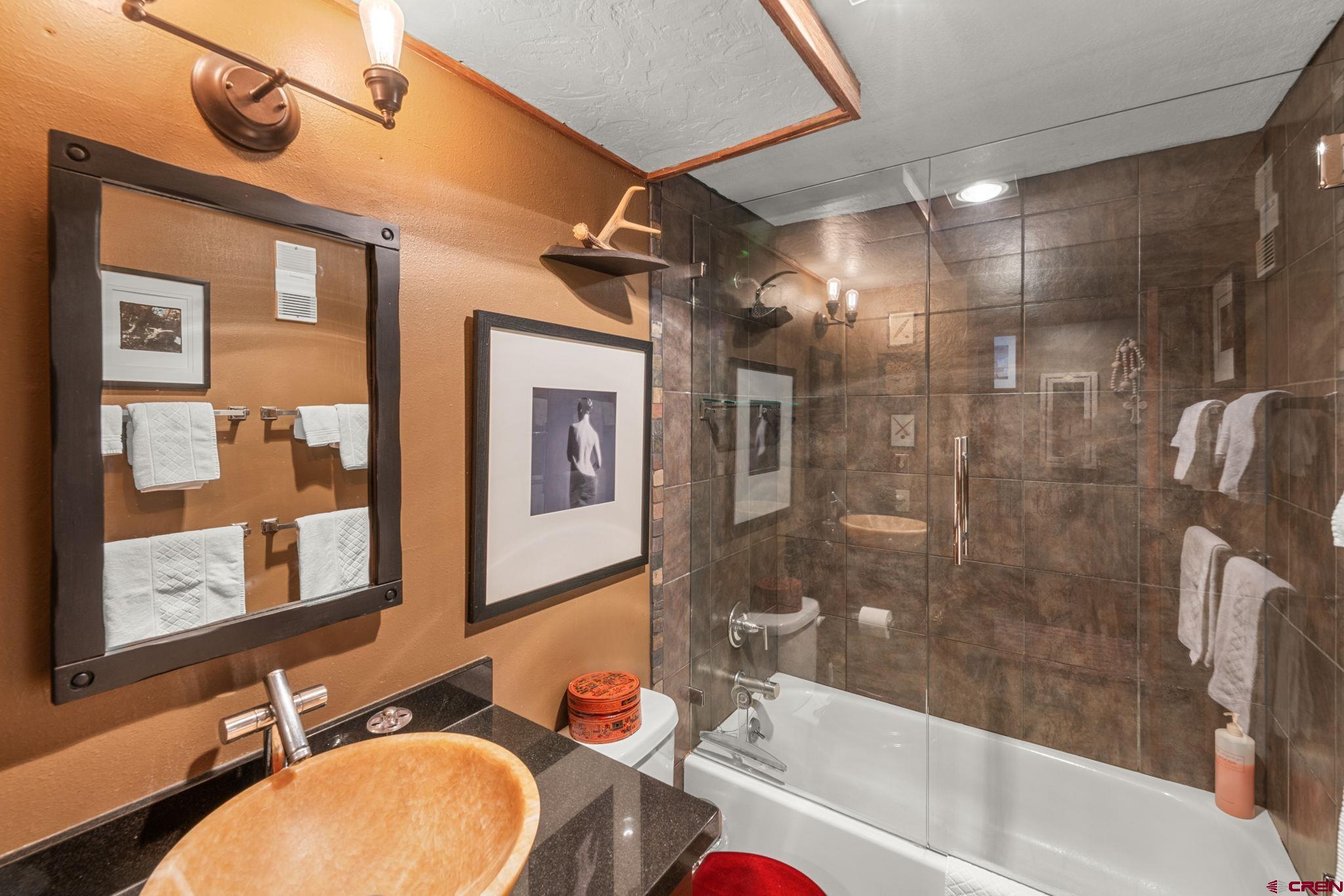 701 Gothic Road, Unit 143 Crested Butte, CO 81225 - Photo 9 of 30 a bathroom with a granite countertop bathtub sink vanity mirror and toilet