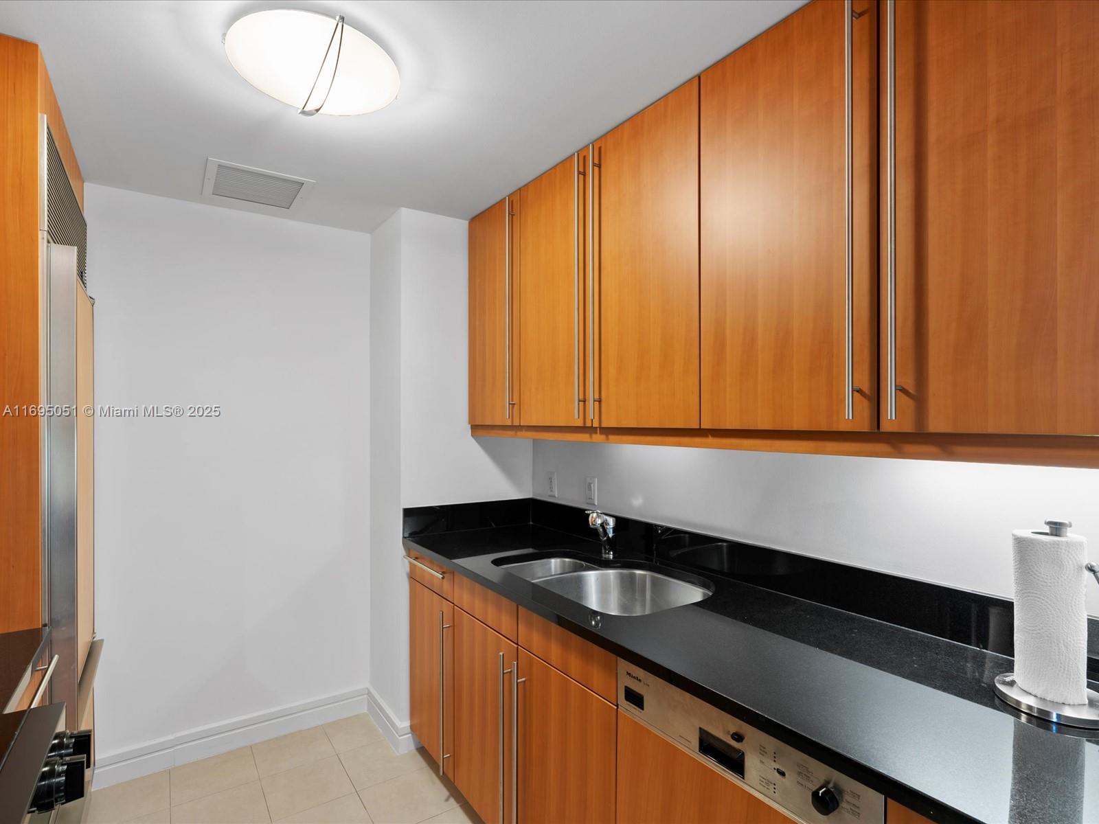 1435 Brickell Avenue, Unit 3601 Miami, FL 33131 - Photo 15 of 42 a kitchen with a sink and cabinets