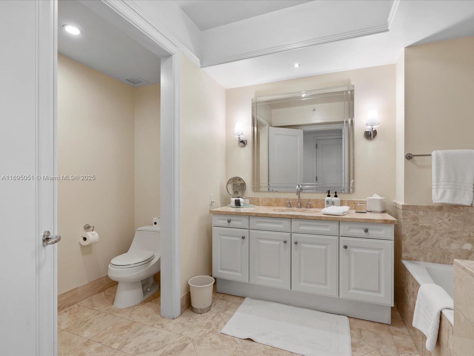 1435 Brickell Avenue, Unit 3601 Miami, FL 33131 - Photo 27 of 42 a spacious bathroom with a granite countertop toilet a sink and a mirror