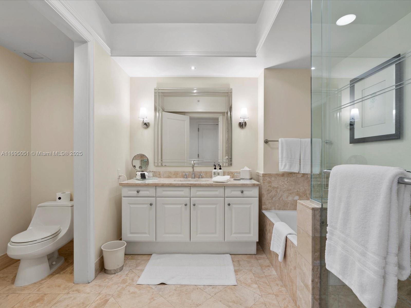1435 Brickell Avenue, Unit 3601 Miami, FL 33131 - Photo 28 of 42 a spacious bathroom with a granite countertop toilet a sink and a mirror