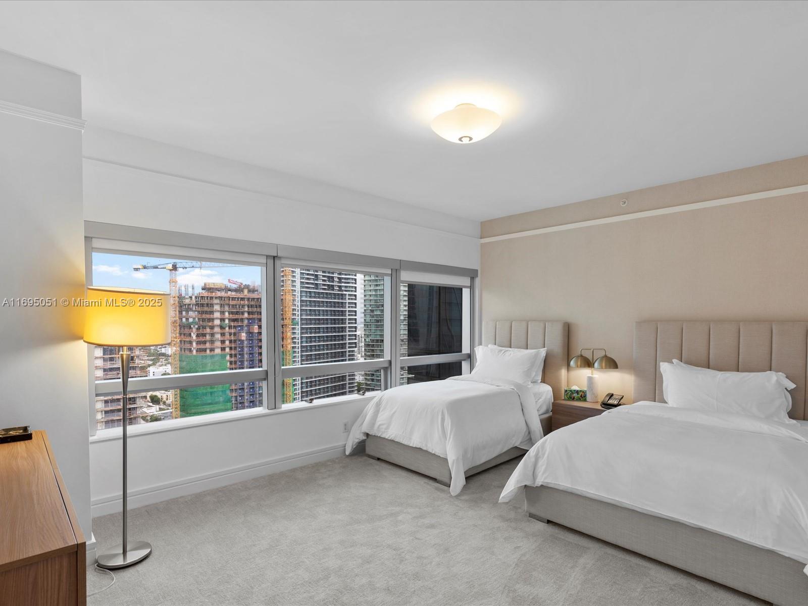 1435 Brickell Avenue, Unit 3601 Miami, FL 33131 - Photo 29 of 42 a bedroom with two beds and a large window