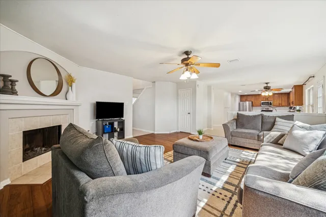 a living room with furniture a fireplace and a floor to ceiling window