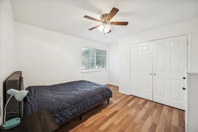 wooden floor in an empty room with a ceiling fan