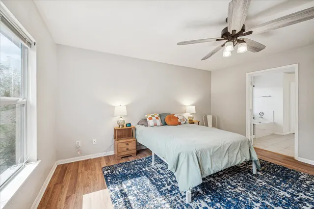 a bedroom with a bed a chandelier and wooden floor
