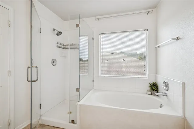 a spacious bathroom with a double vanity sink a large mirror a bathtub and shower