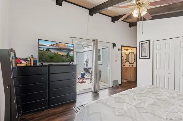 a bedroom with a bed a dresser next to a window