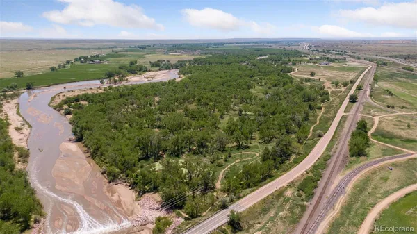an aerial view of a residential houses with outdoor space and trees