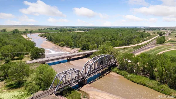a view of a balcony with wooden floor and fence