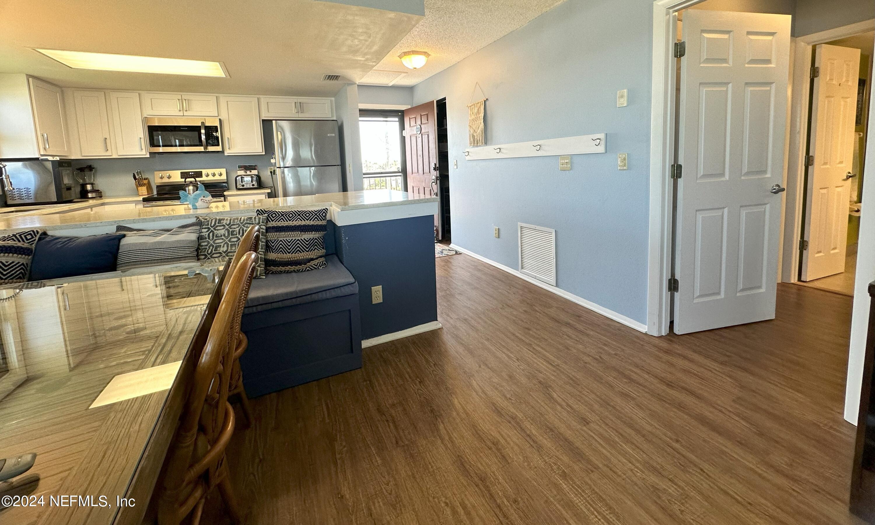 2100 Ocean Shore Boulevard, Unit 3010 Ormond Beach, FL 32176 - Photo 3 of 32 a view of a kitchen with kitchen island wooden floors appliances and cabinets