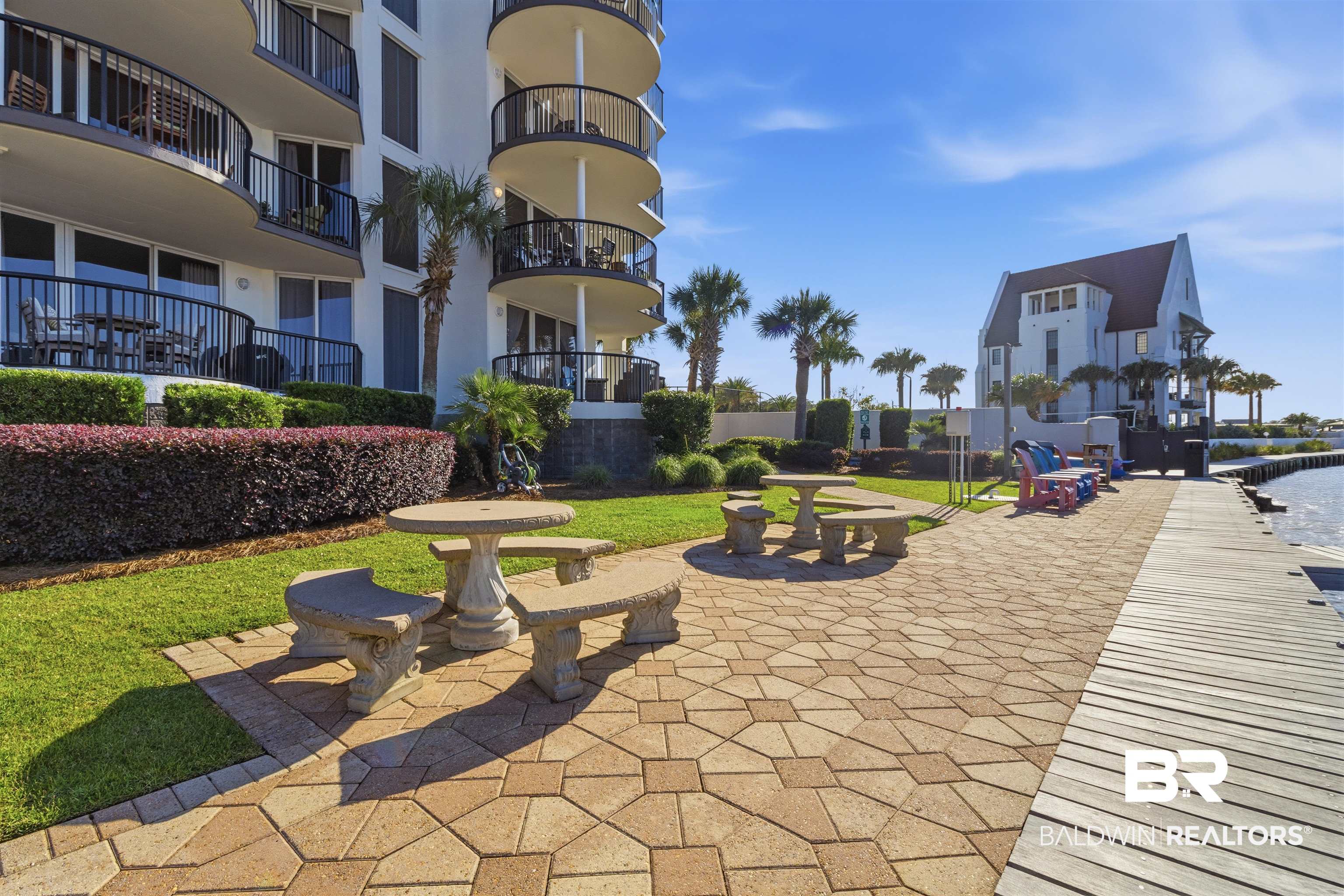 3564 Bayou Road, Unit 203 Orange Beach, AL 36561 - Photo 38 of 53 Waterfront patio featuring stone pavers and a wooden boardwalk