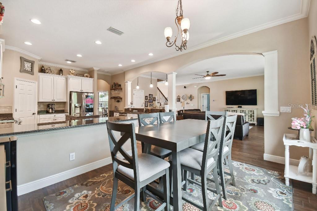 849 John Cressler Drive Seffner, FL 33584 - Photo 14 of 45 a dining room with stainless steel appliances kitchen island granite countertop a table chairs and a chandelier