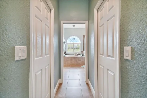 a view of a hallway with wooden floor and a bathroom