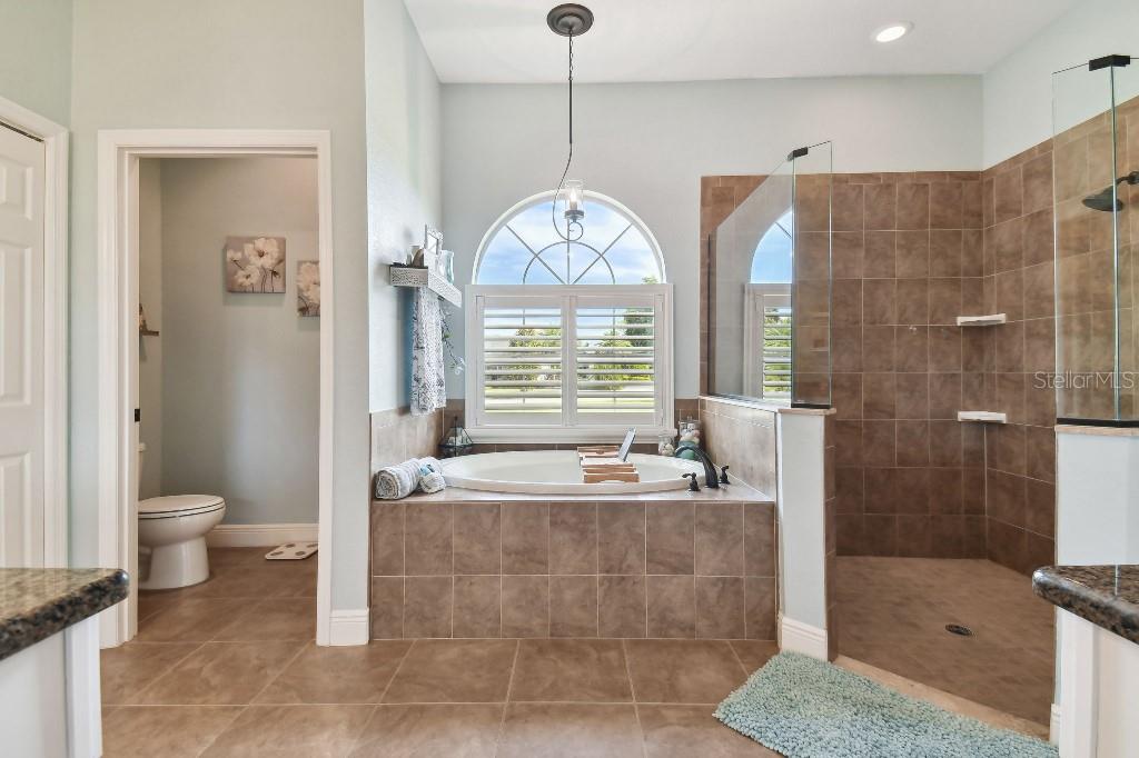 849 John Cressler Drive Seffner, FL 33584 - Photo 23 of 45 a bathroom with a granite countertop sink a toilet a mirror and shower