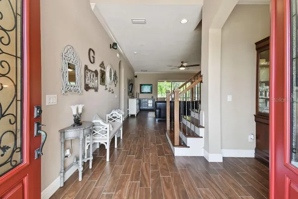 a view of a hallway with wooden floor and furniture