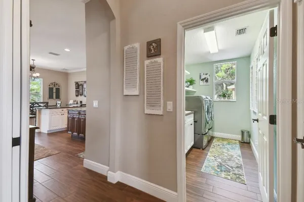 a view of a hallway with wooden floor and a living room
