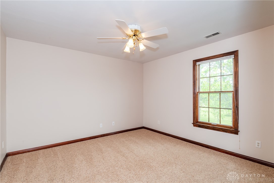 9981 Ridge Acres Lane Englewood, OH 45322 - Photo 30 of 73 This spacious bedroom offers ample natural light and comfortable carpeted flooring, perfect for serene living.