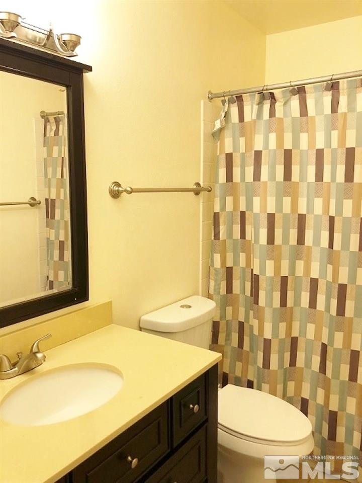 6541 Flower Street Reno, NV 89506 - Photo 12 of 14 a bathroom with a sink a toilet and shower curtain