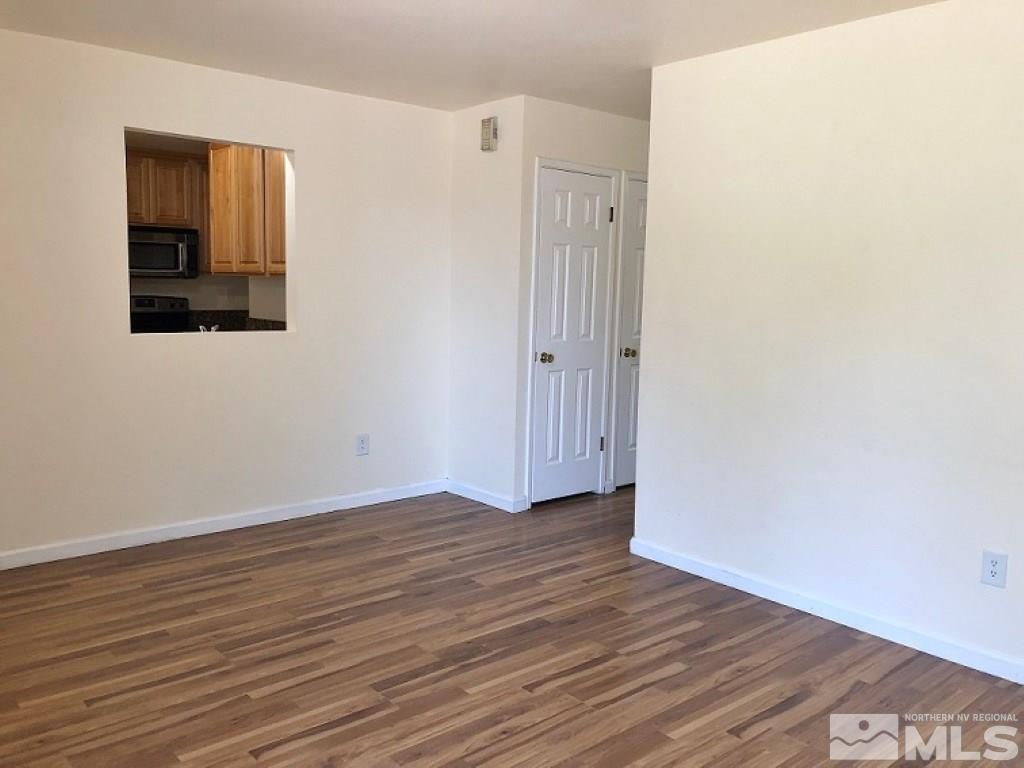 6541 Flower Street Reno, NV 89506 - Photo 7 of 14 a view of an empty room with wooden floor and a window