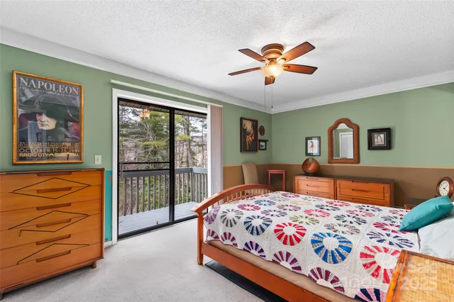 a bedroom with a balcony a bed and a dresser in it