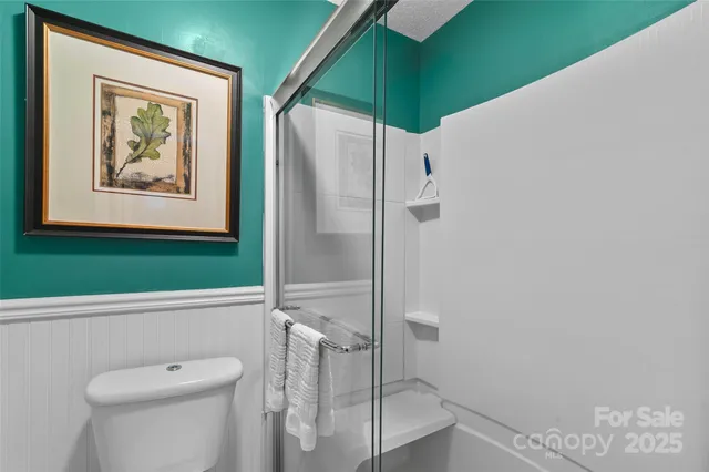 a bathroom with a toilet and a shower