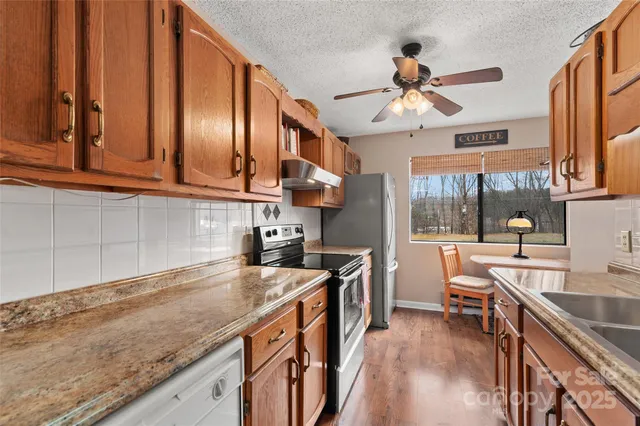 a kitchen with stainless steel appliances granite countertop a sink stove and cabinets