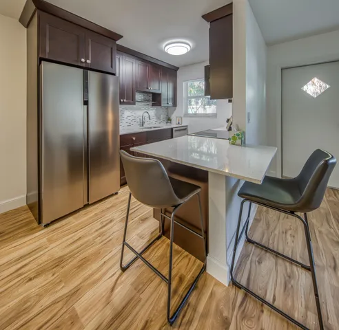 a kitchen with kitchen island wooden floors and stainless steel appliances