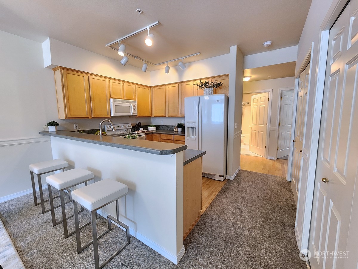 440 Maple Avenue Southwest, Unit A203 Renton, WA 98057 - Photo 19 of 33 a kitchen with stainless steel appliances granite countertop a stove a sink a refrigerator and a refrigerator