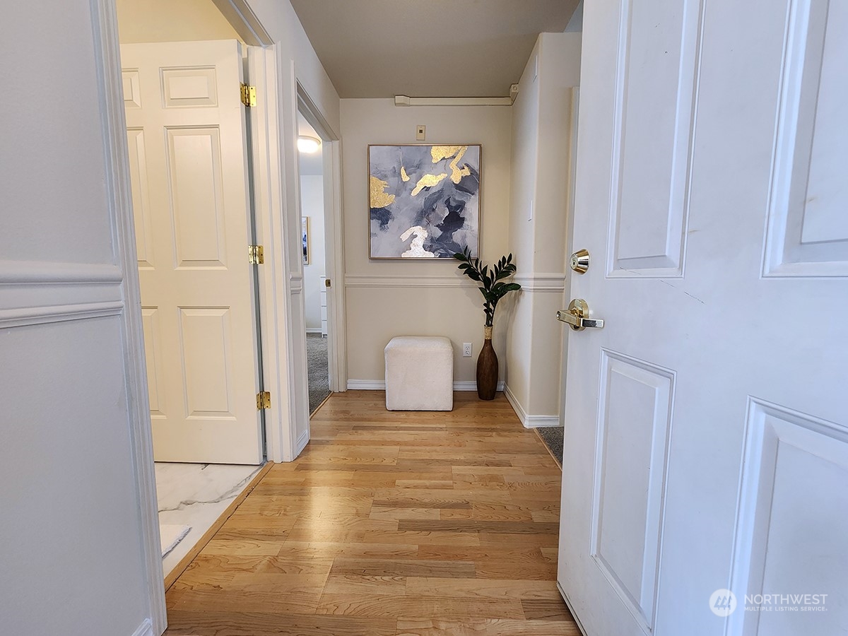 440 Maple Avenue Southwest, Unit A203 Renton, WA 98057 - Photo 5 of 33 a view of a hallway with wooden floor and a cabinet