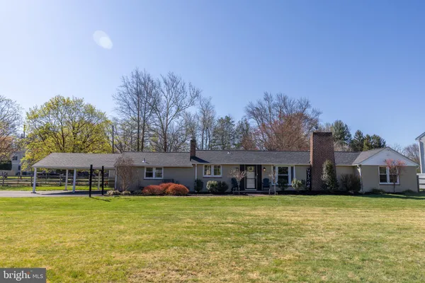 a front view of a house with a garden and swimming pool