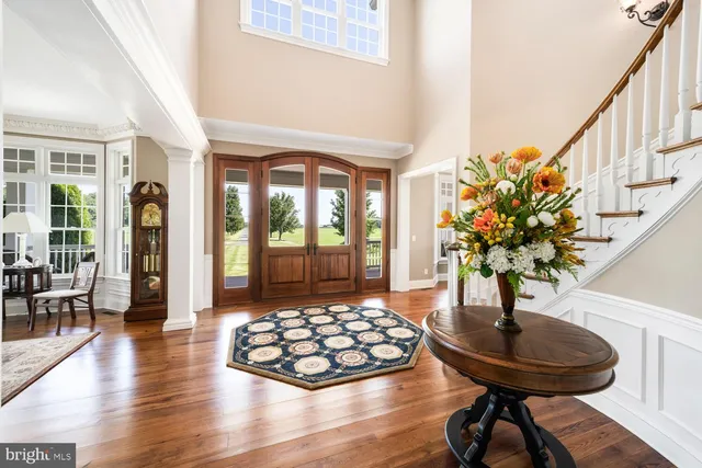 a view of a kitchen with stainless steel appliances granite countertop a stove top oven a chimney cabinets and wooden floor