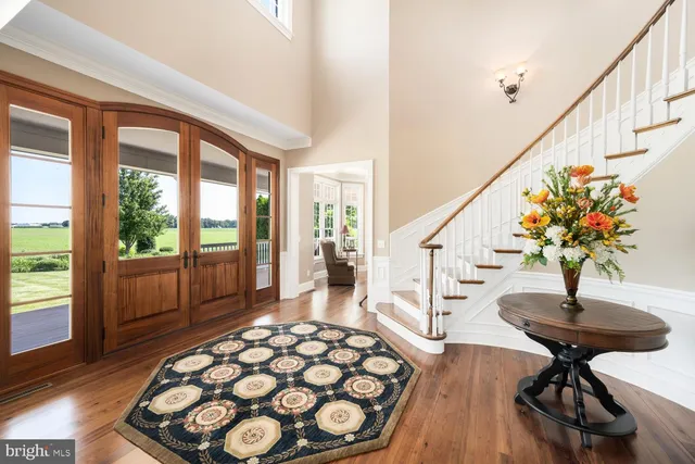 a dining room with wooden floor and a floor to ceiling window