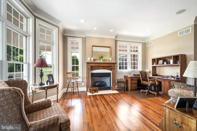 a view of a hallway with wooden floor and workspace