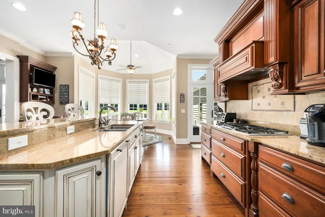 a view of a dining room with furniture a chandelier and wooden floor