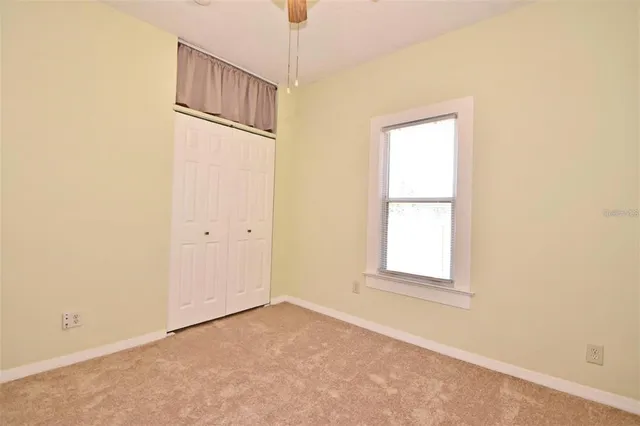 a view of a livingroom with a fireplace a ceiling fan and wooden floor