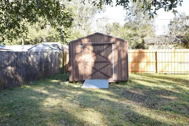 a view of a small house with a big yard and a large tree