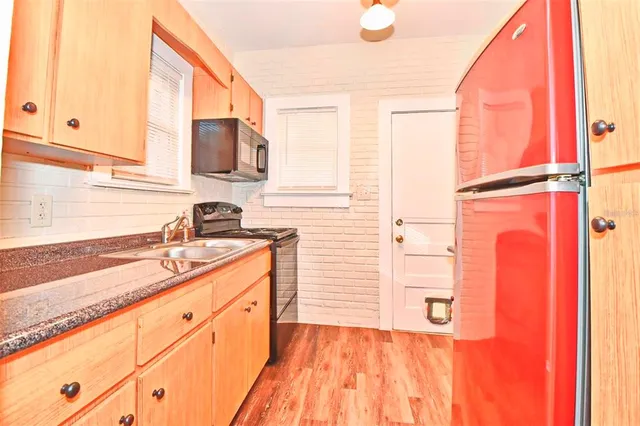 a kitchen with granite countertop a stove sink and cabinets