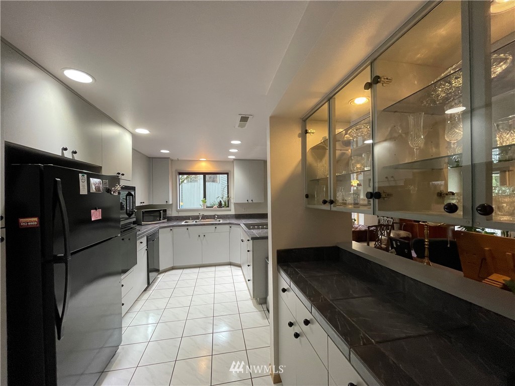 3300 Northeast 164th Street, Unit H2 Ridgefield, WA 98642 - Photo 5 of 24 a large kitchen with a large counter top space a sink stainless steel appliances and cabinets