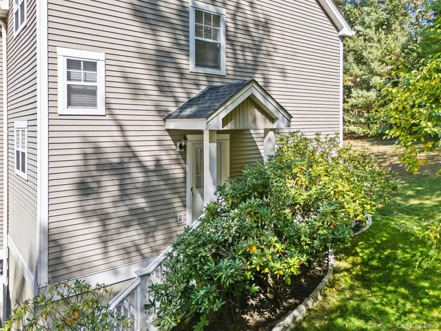 a view of a house with a yard and potted plants
