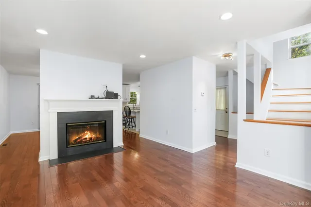 a living room with wooden floor and a fireplace