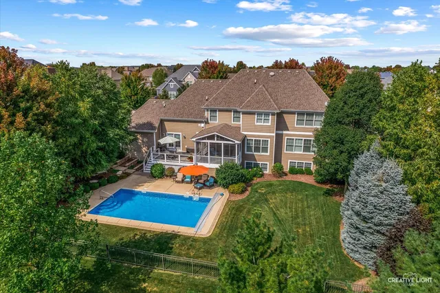 an aerial view of a house with porch yard basket ball court and trampoline